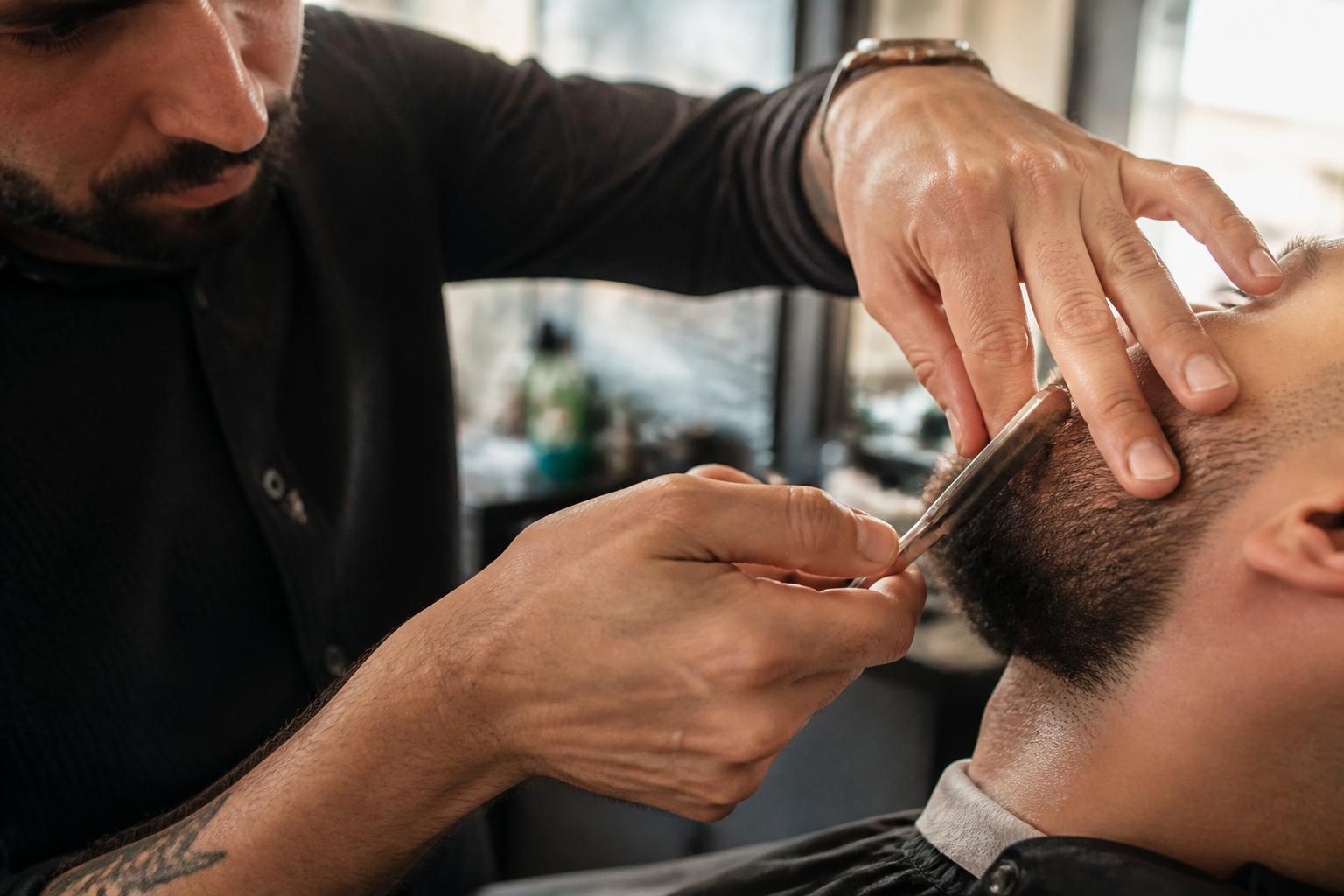 Barber carefully shaping a client's beard